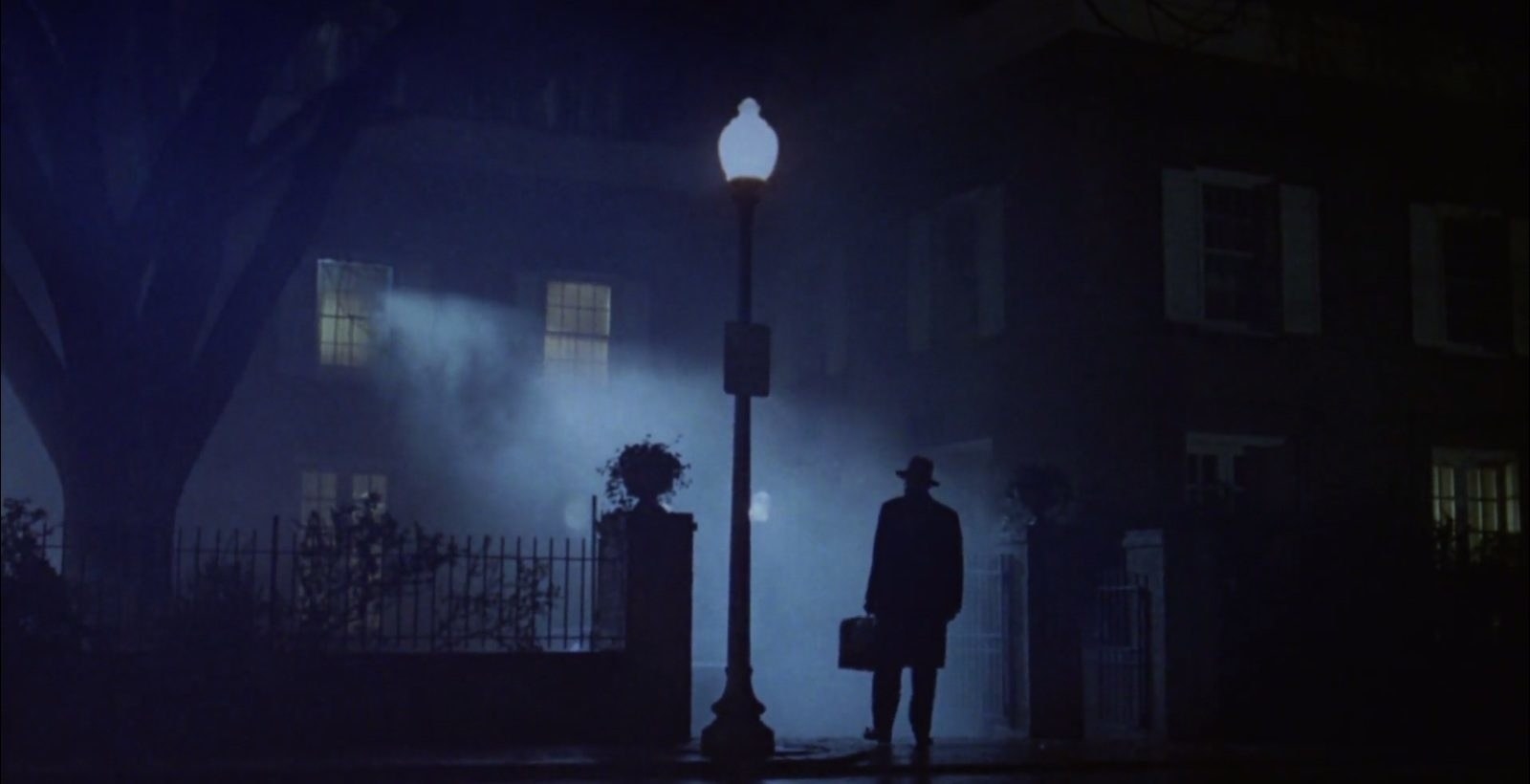 A silhouette of Father Merrin standing in front of Regan&#x27;s home