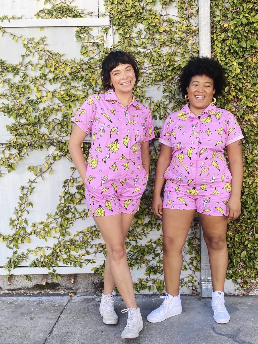 two models wears the pink shortalls covered in illustrated bananas 