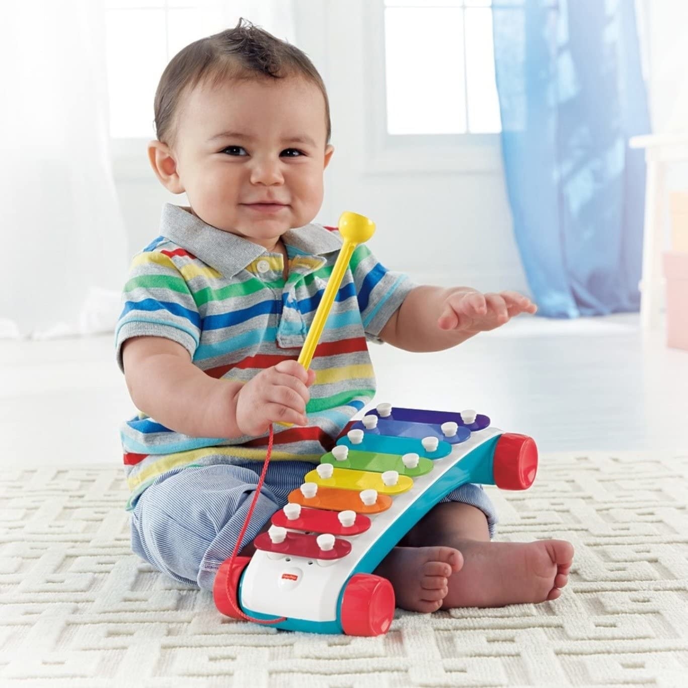 a child playing with a rainbow colored xylophone