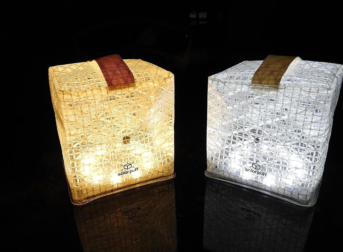 Two solar lights lit up in a dark room