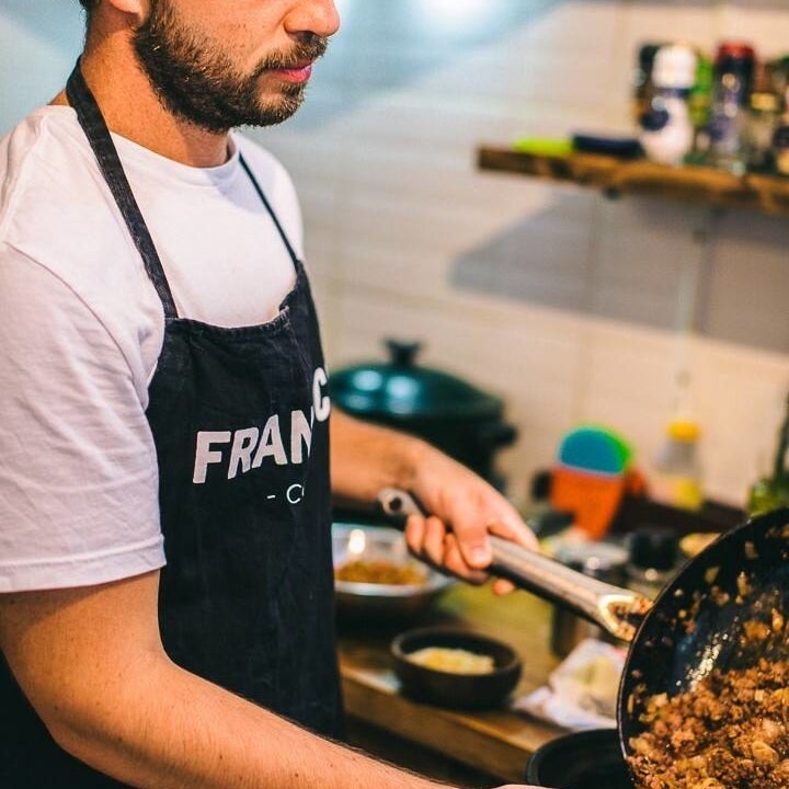 Fran holding a frypan with a meat filling for empanadas 