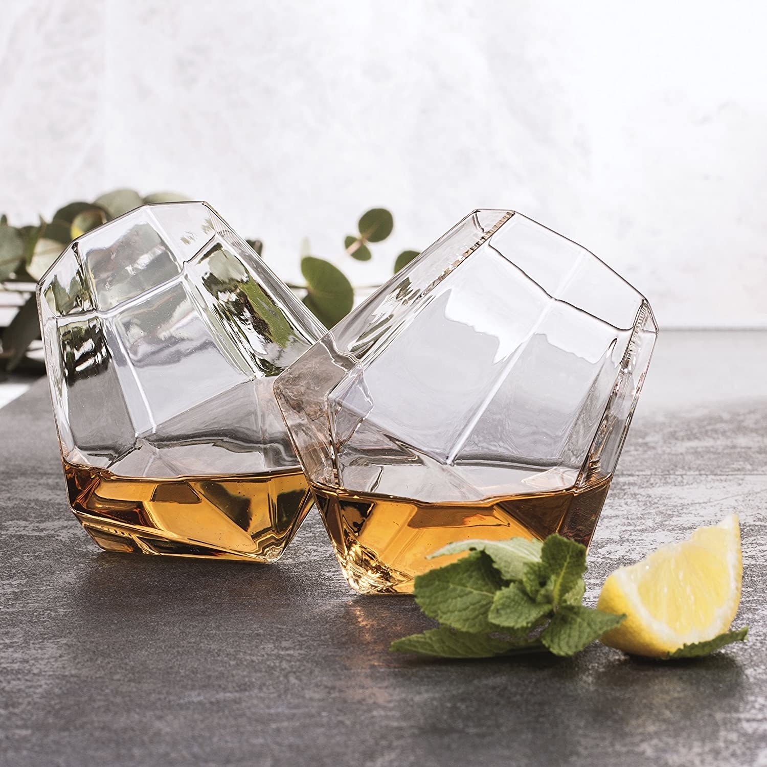 Two diamond-shaped tumblers filled with whiskey