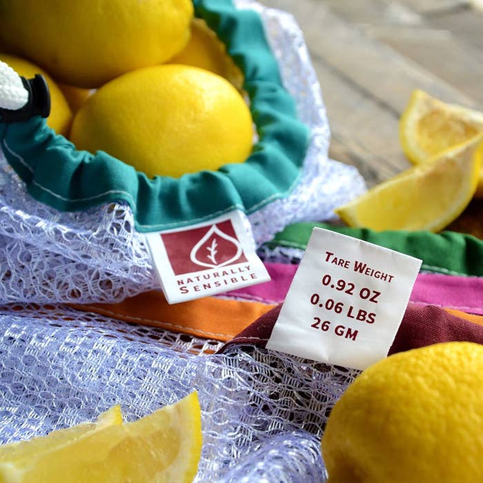 White mesh bag with colorful accents filled with lemons