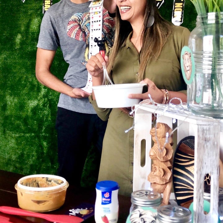 Natalie and Chad, the hosts, smiling as they cook and shuffle playing cards
