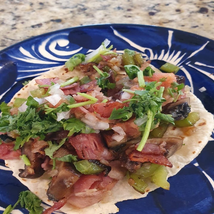 taco topped with meat, salsa, and coriander
