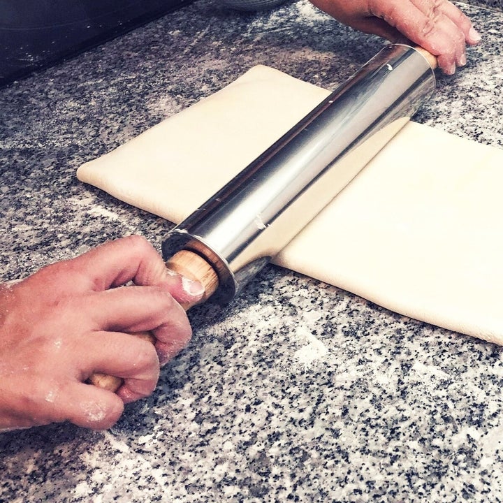 rolling pin being used to flatten pastry for custard tarts 