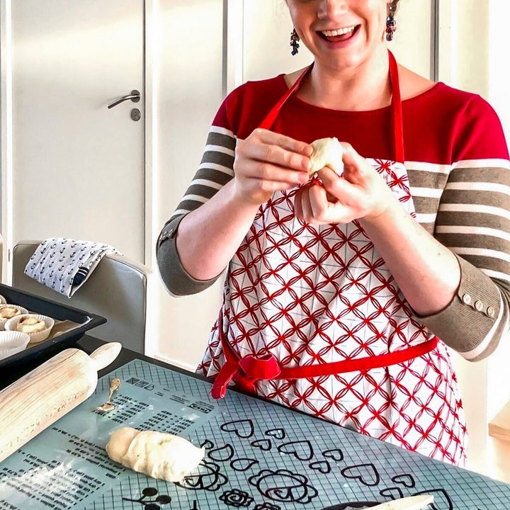 lady looking happy while she shapes a pastry in the kitchen