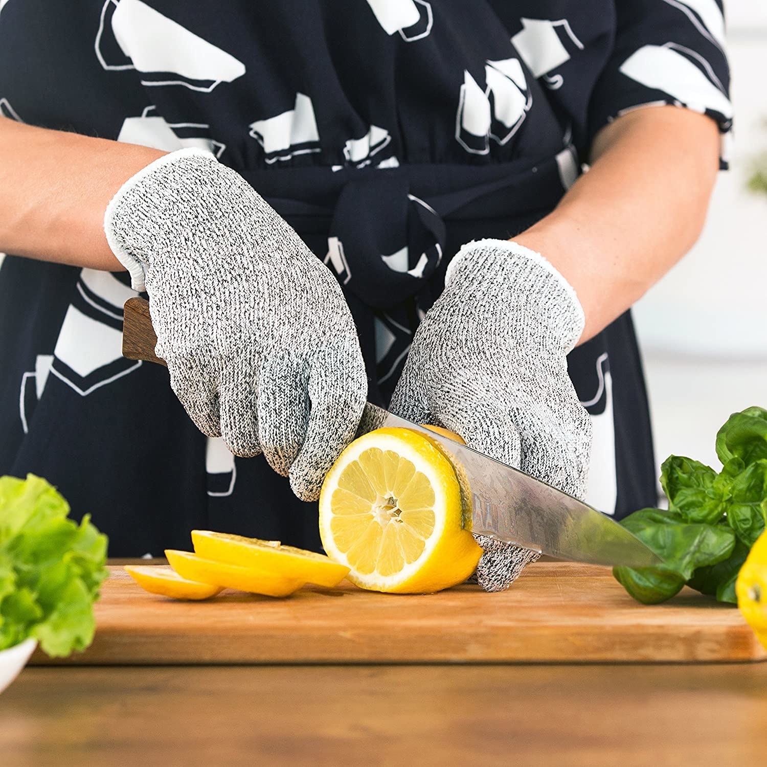 A person cutting a lemon while wearing the gloves