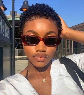 Model wearing the hair oil with short curls