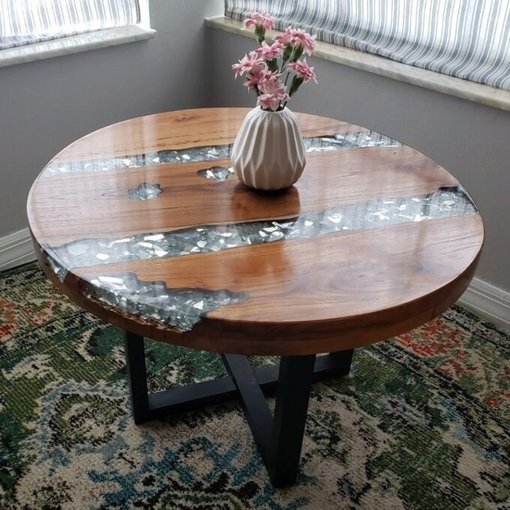 A reviewer's image of their table, showing the shiny natural wood and the shimmering lines of crystal. The legs are black and cross together in the middle. 