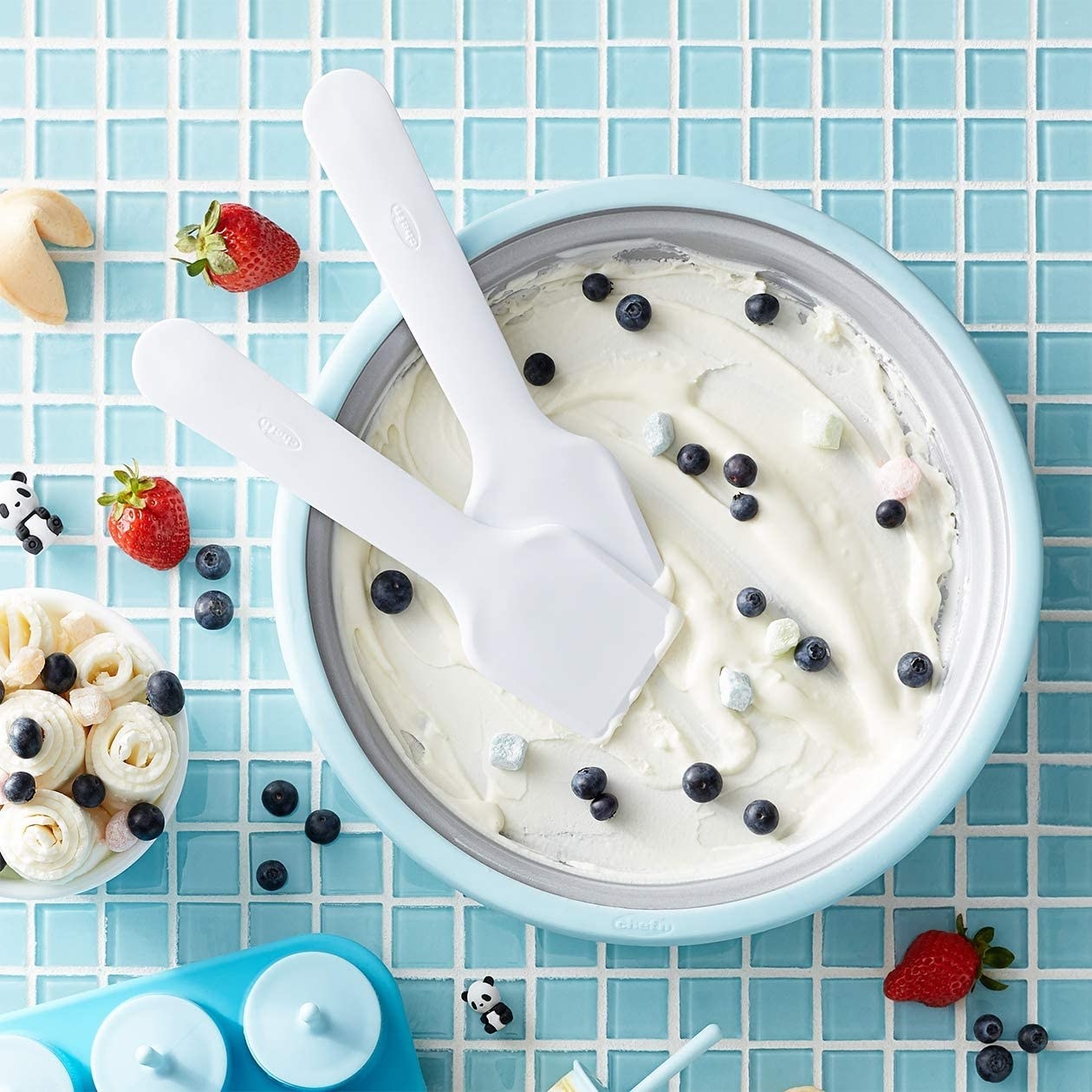 The ice cream mixer with vanilla ice cream and berries on it