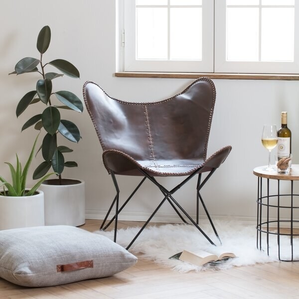 A thin chair made with leather over a metal frame