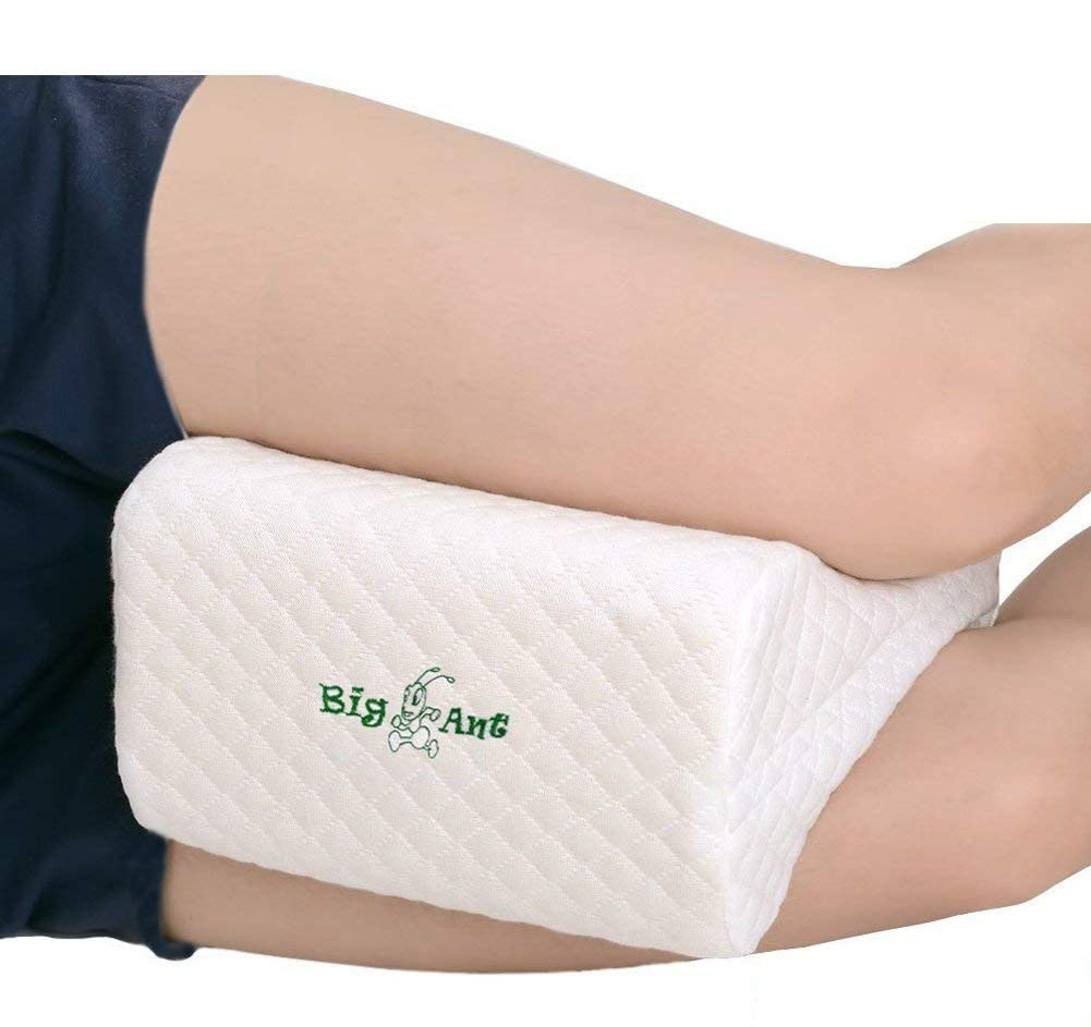 A person cradling a small rectangular pillow between their thighs and knees