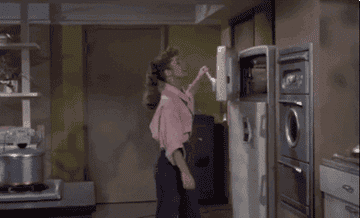debbie reynolds in the movie &quot;susan slept here&quot; opening a freezer and waving cool air in her face with the door