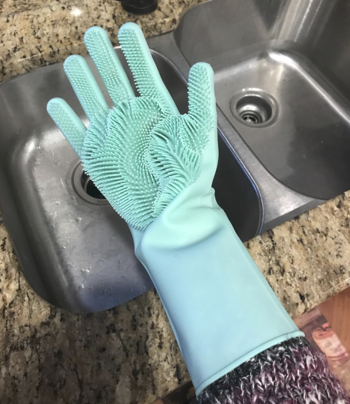 reviewer wearing green gloves with tiny rubber-like bristles on the palms