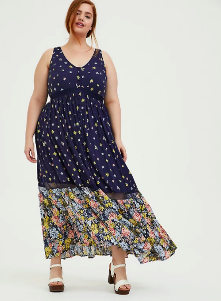 model wearing the sleeveless maxi dress with navy floral print then multicolor floral print at bottom starting at knees