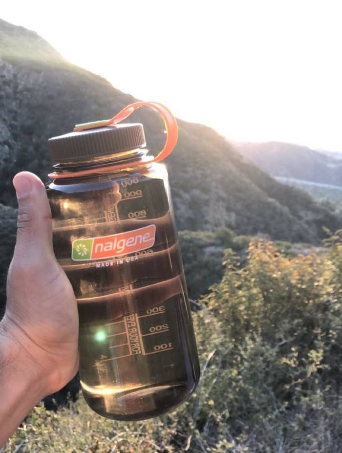 Reviewer holding their water bottle while hiking
