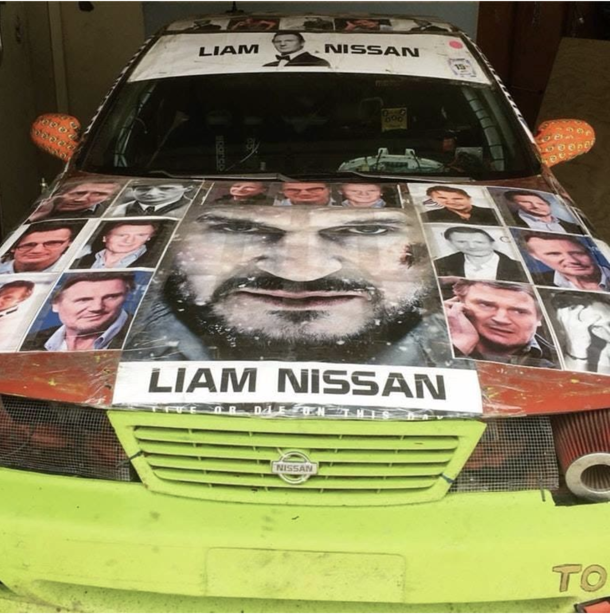 A Nissan car with photos of Liam Neeson on it