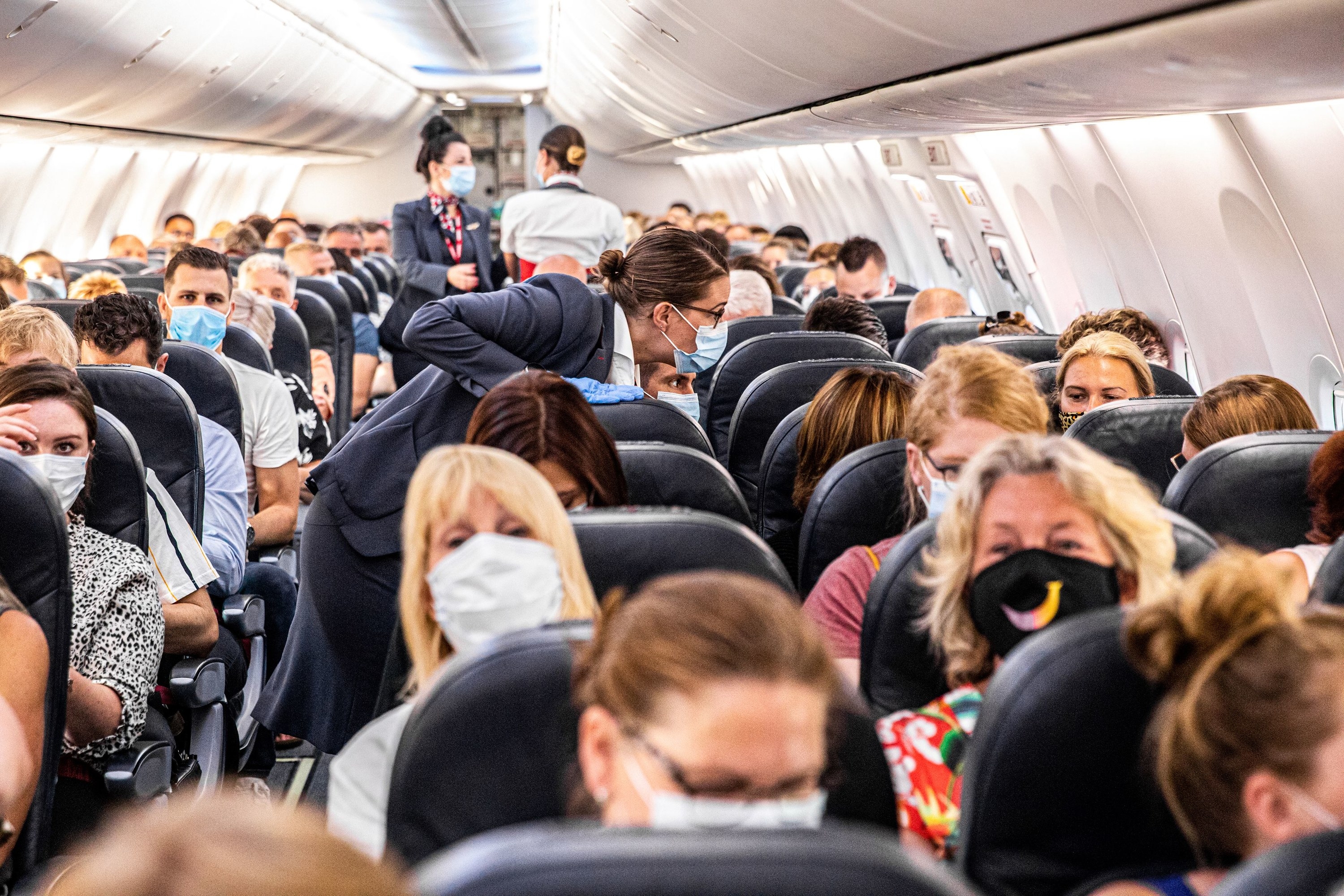 Passengers wear masks on a packed airplane
