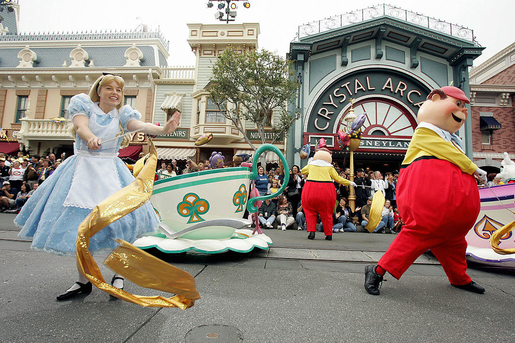 Characters from Alice in Wonderland dance down Disneyland Main Street.