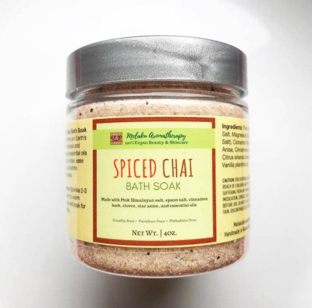 A clear container of Spiced Chai Bath Soak filled with a pinkish mixture