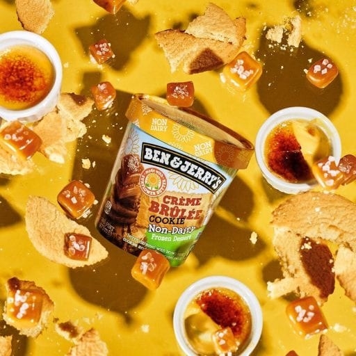 A Ben &amp;amp; Jerry&#x27;s ice cream pint is floating in the air. All around it are floating ramekins with creme brulee in them, chunks of salted caramel, and crushed sugar cookie bits.