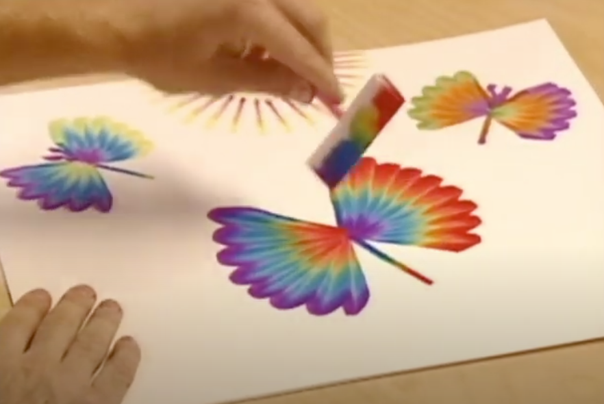 A screenshot of a kid painting rainbow butterflies with Rainbow Art.