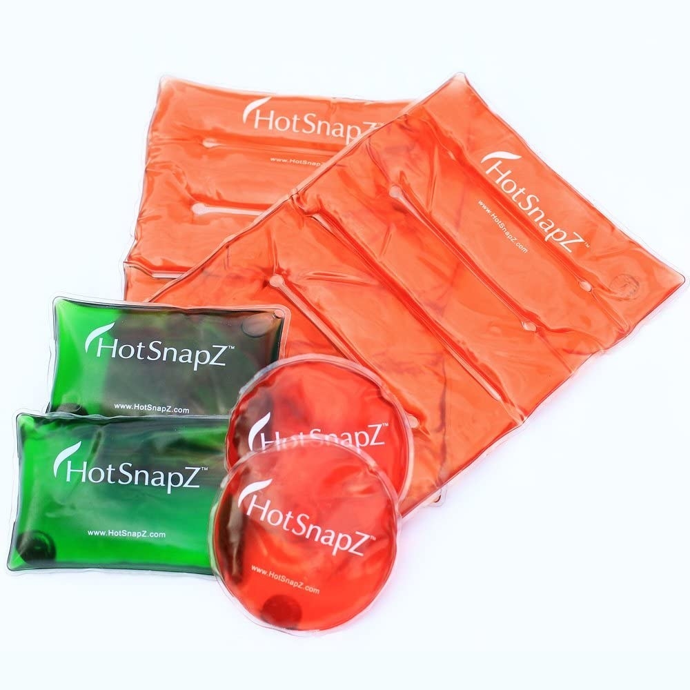 Two sets of three different sized heat packs in green and orange