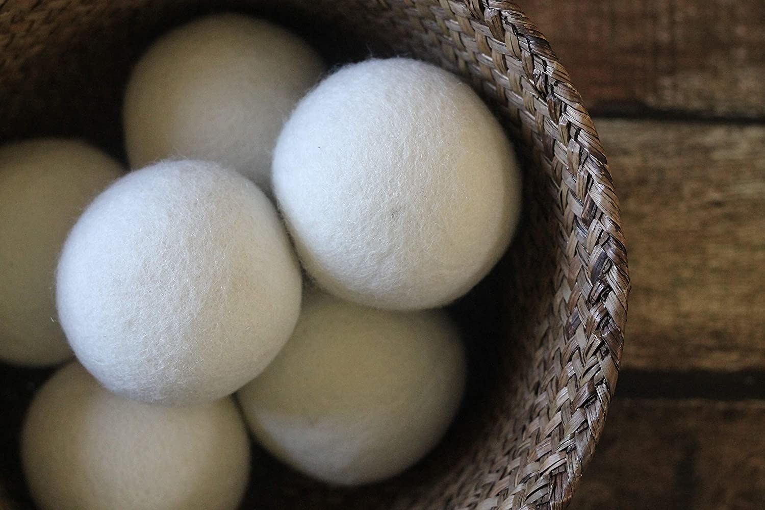A basket full of six white wooly dryer balls