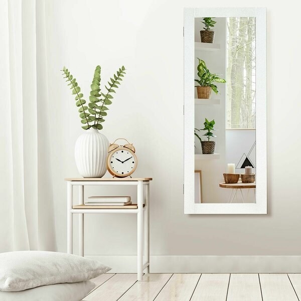 A wall mounted mirror with a white frame and plenty of velvet storage space inside for hanging delicate jewelry
