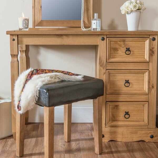 A rustic vanity with a mirror, space for a chair or stool, and three shelves with round metal handles 