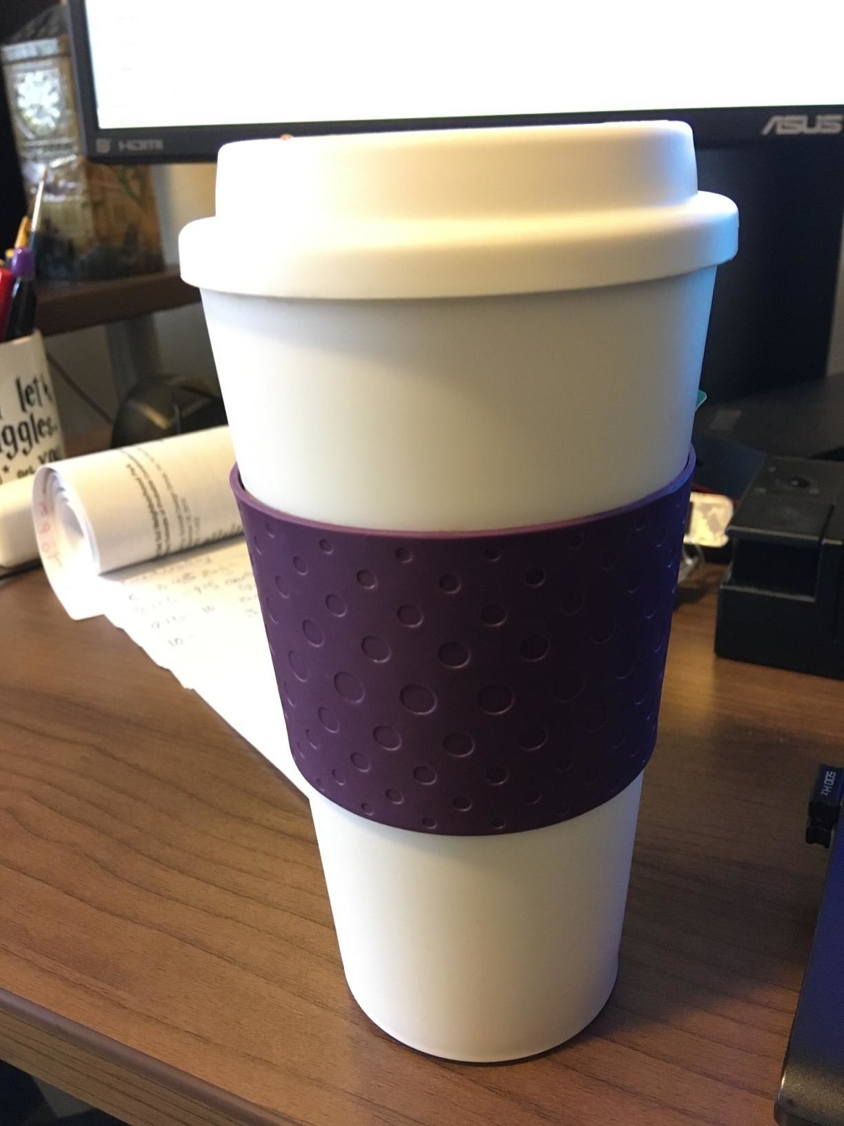 Reviewer&#x27;s photo of a white coffee mug with a purple sleeve