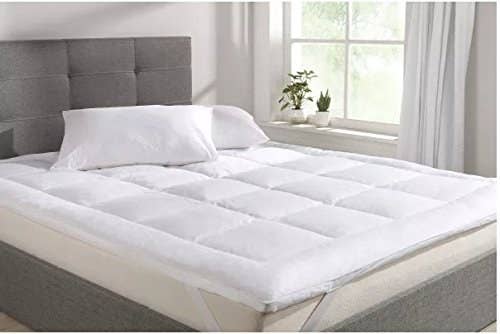 A white mattress topper on a double bed