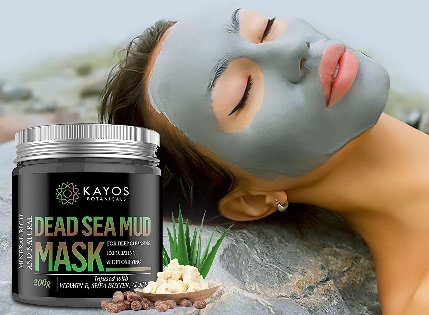 A woman with a mud mask on lying next to a container of Kayos Dead Sea Mud Mask