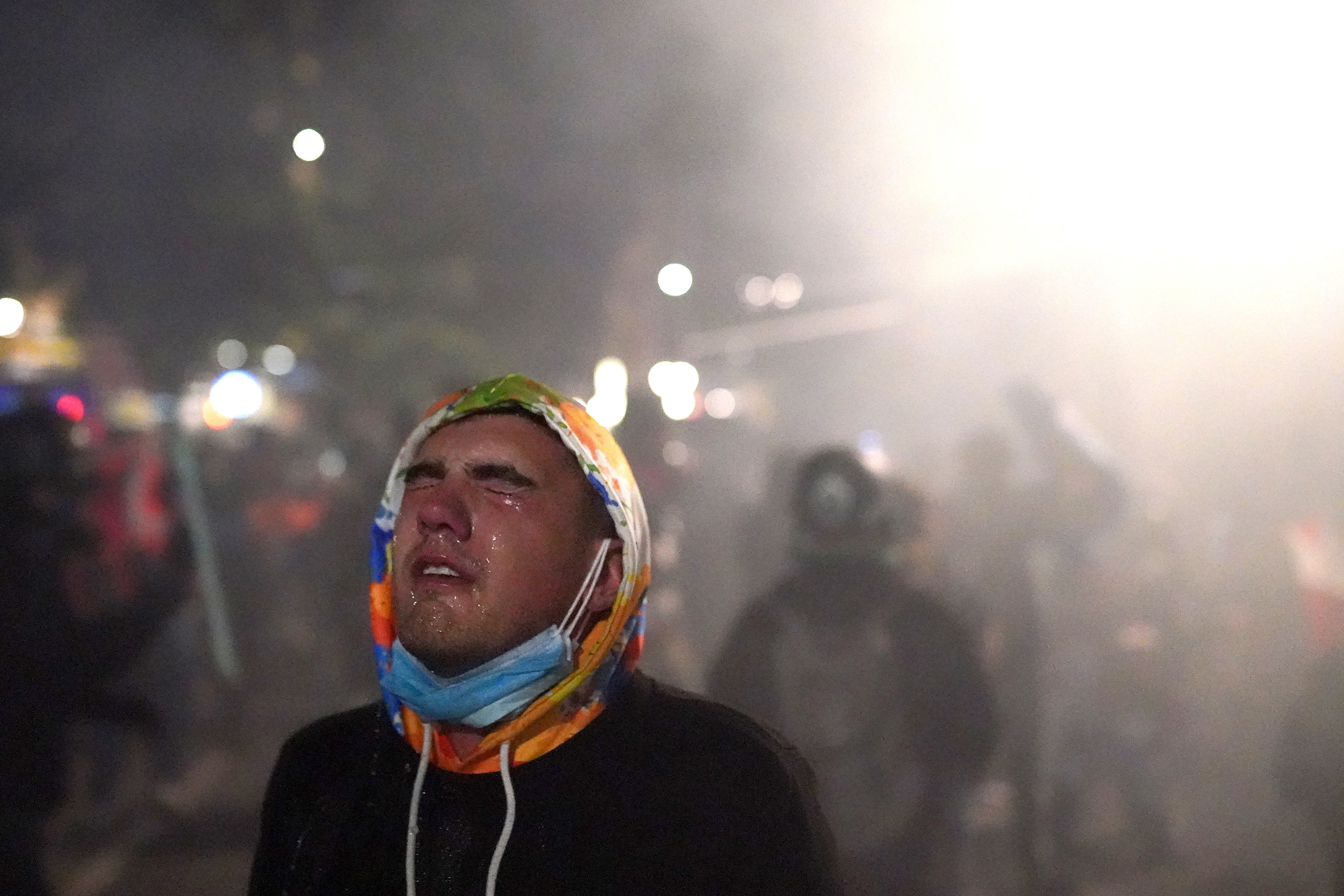 A protester closes his eyes as water steams from them after tear gas was fired by federal officers during a demonstration