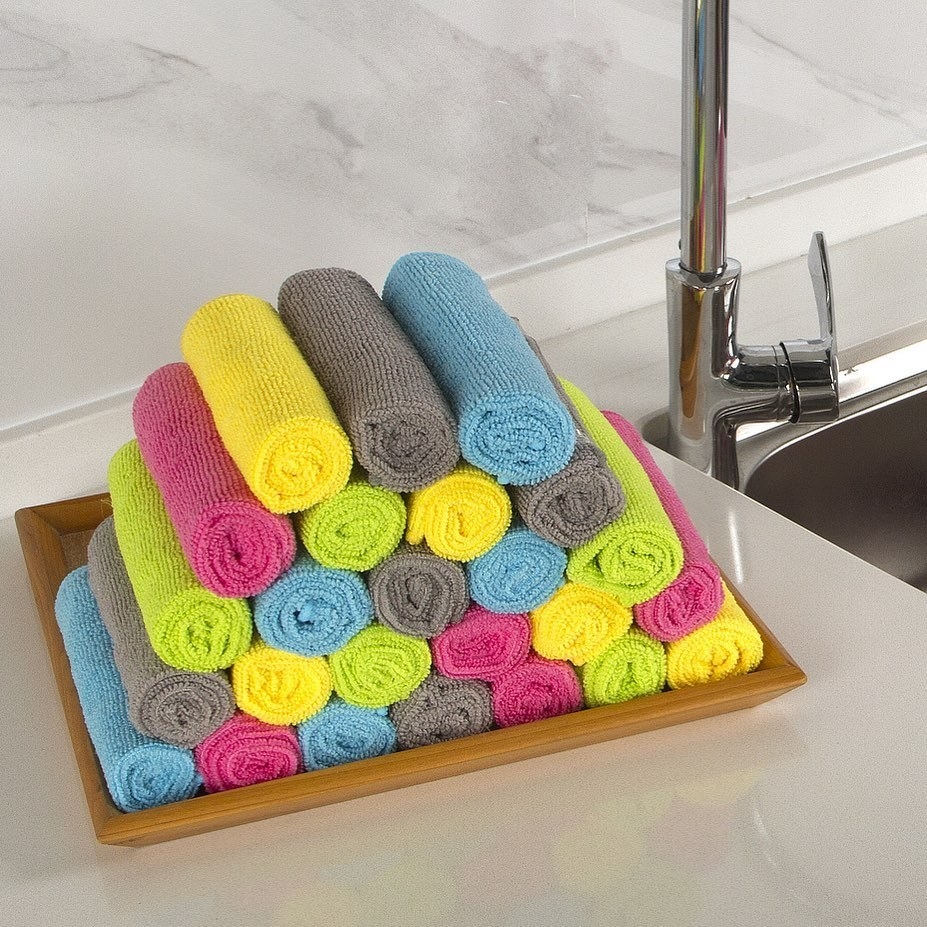 A neatly stacked pile of rolled up cloths on a kitchen counter