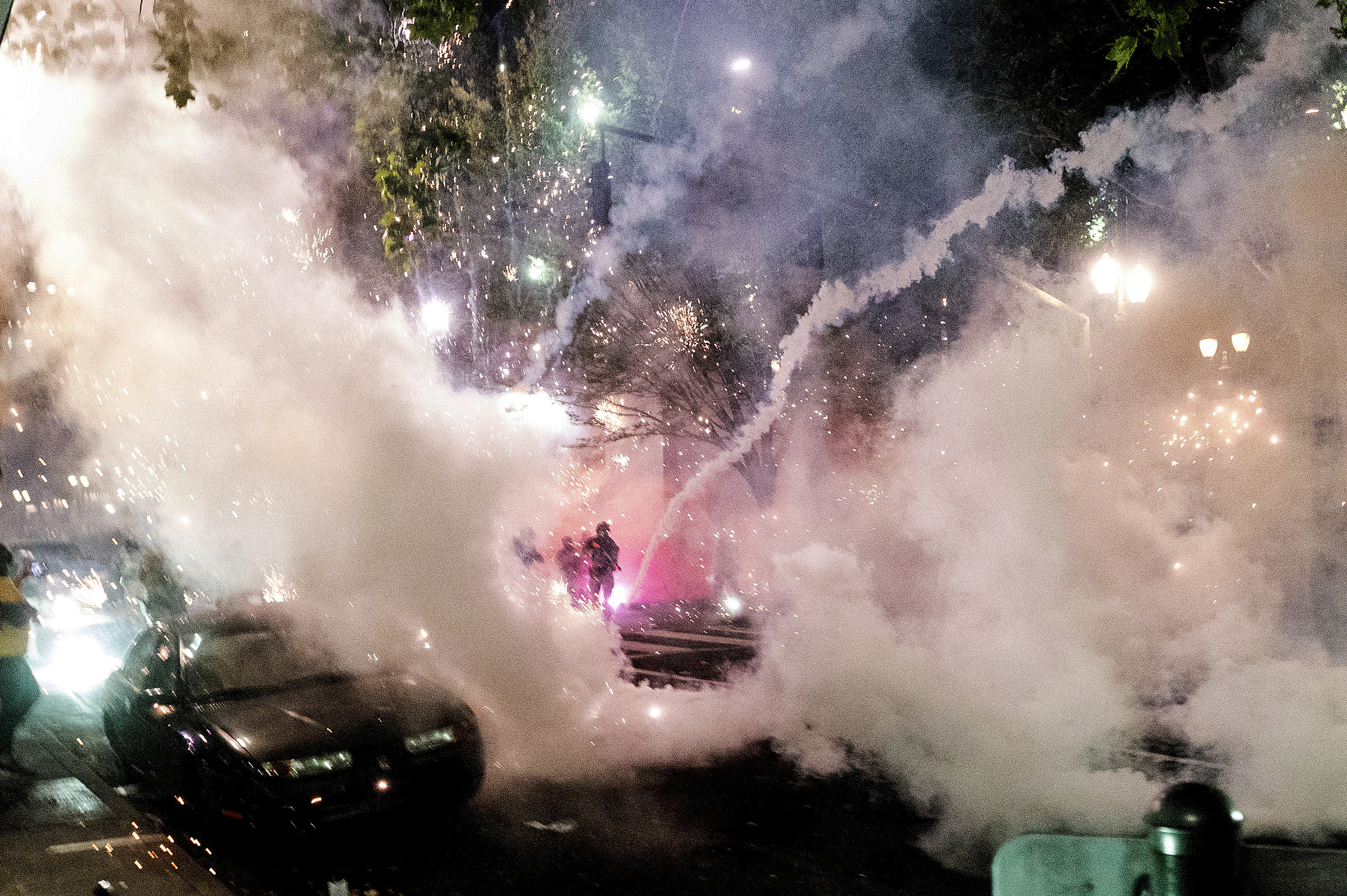 Smoke, tear gas, and sparklers fill the sky as federal officers advance to disperse protesters 