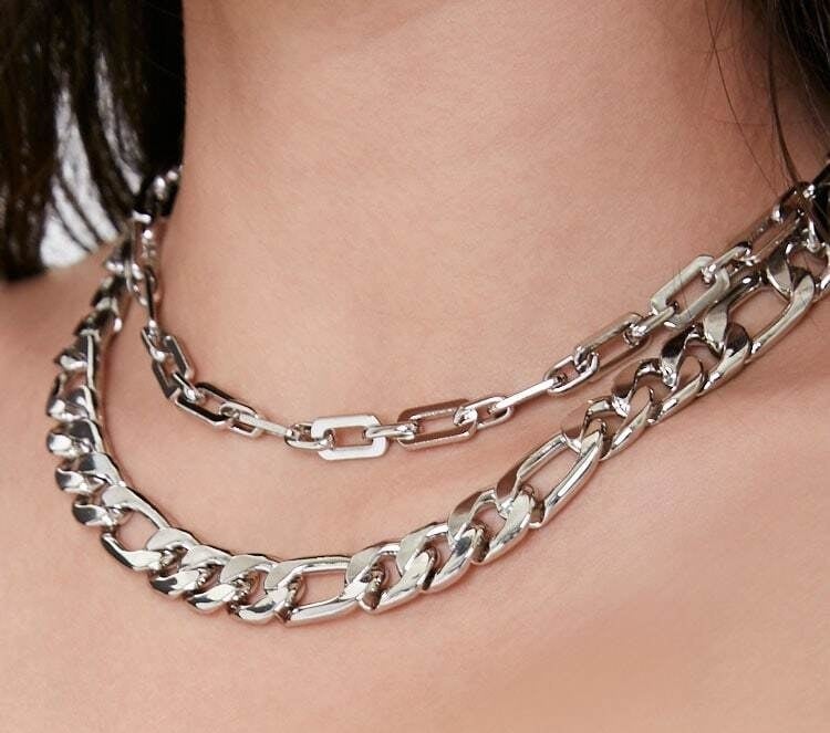A two layer necklace with the top, smaller chain hitting the collarbone and the larger, longer chain hitting right below it