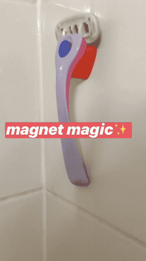 gif of a BuzzFeed editor's hand pulling the razor off its magnetic base attached to the shower wall 