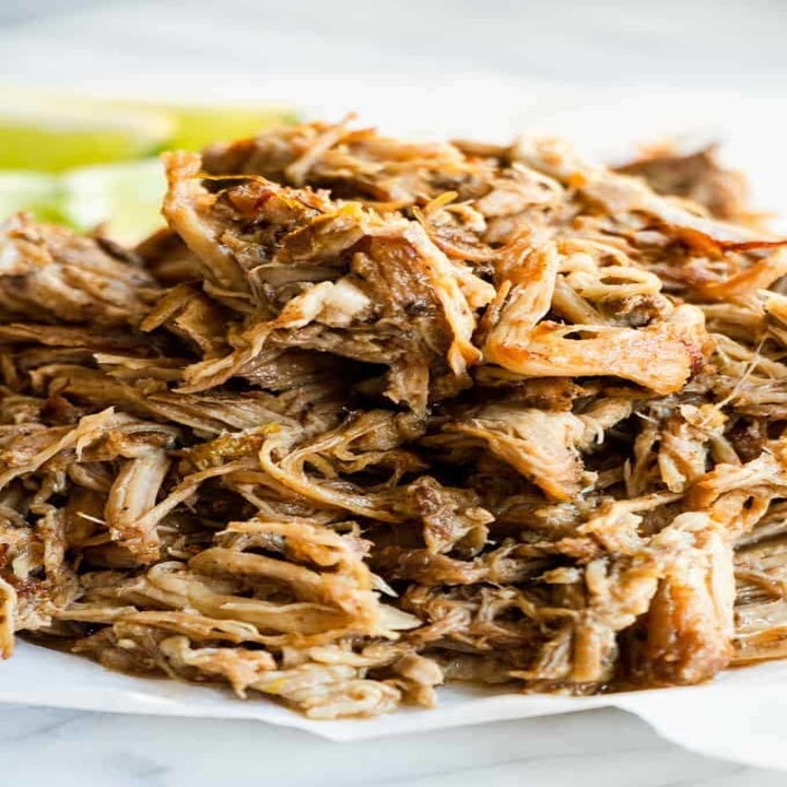 A heaping pile of shredded pork carnitas on a plate.