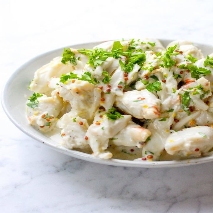 A bowl of lump crab meat with fresh herbs for seafood bisque.