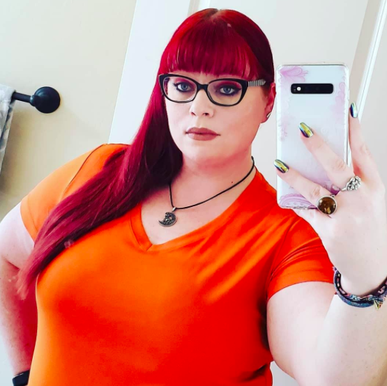 Reviewer takes selfie while wearing an orange moisture-wicking tee