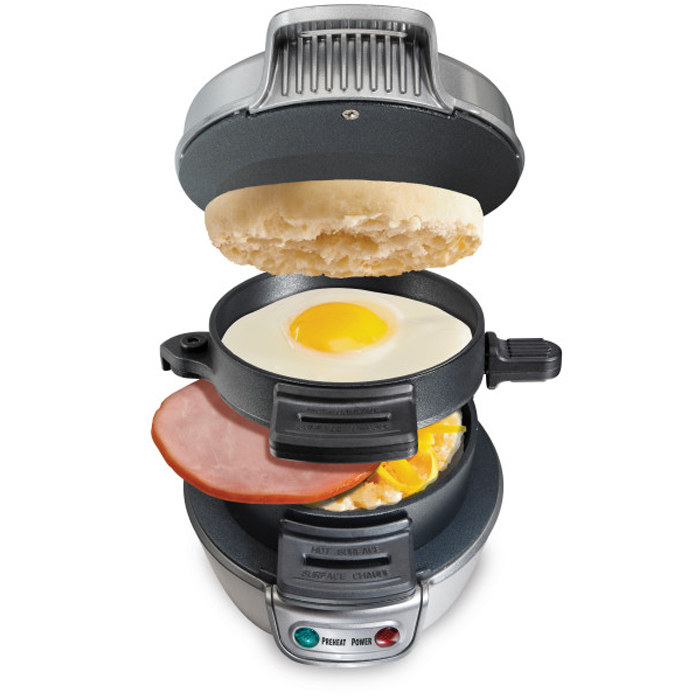The sandwich maker with egg, meat, bread, and cheese inside 