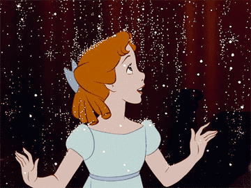 Wendy from &quot;Peter Pan&quot; clasps her hands in excitement as glittering pixie dust falls around her.