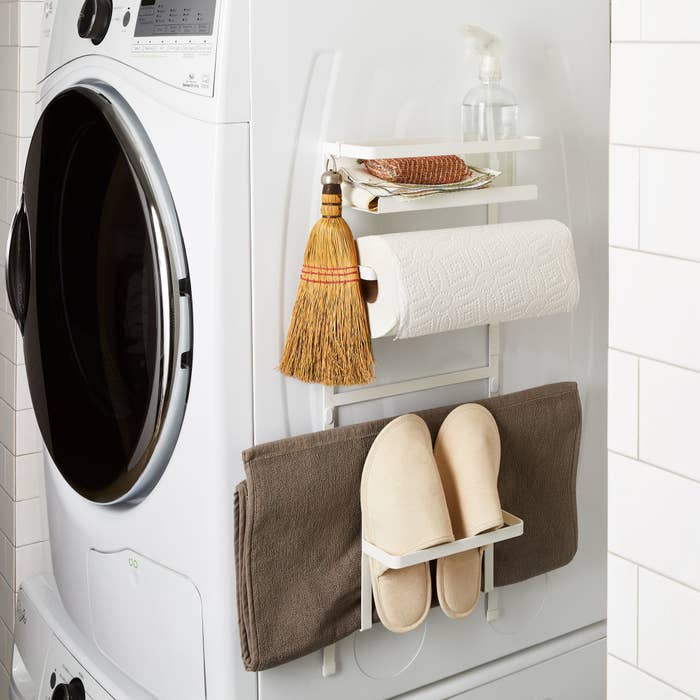 Magnetic rack on side of washing machine holding slippers and broom