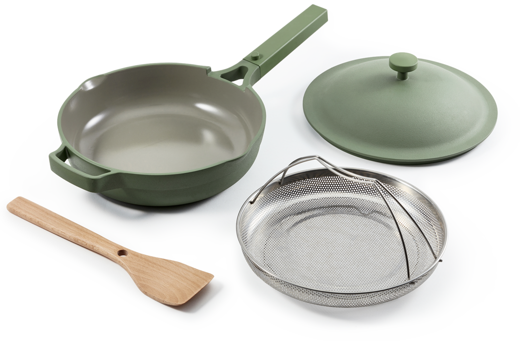 The pan in sage green with steamer basket and spatula