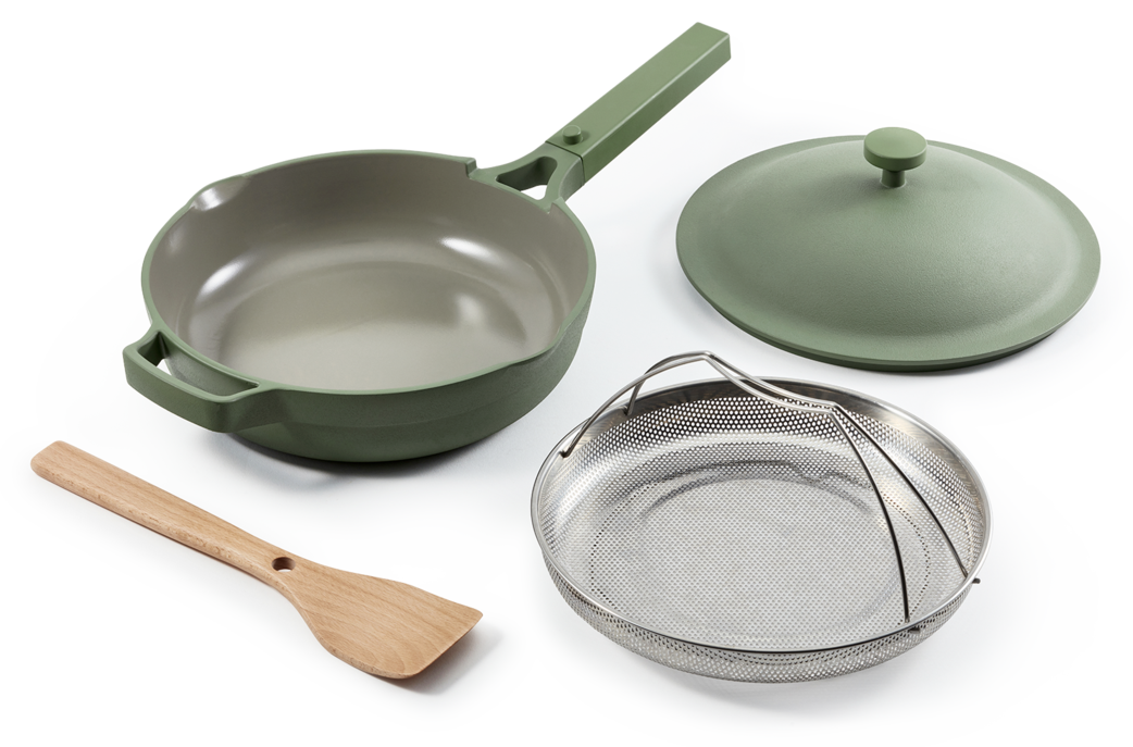 The pan in sage green with steamer basket and spatula