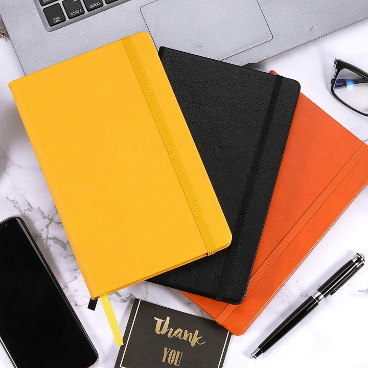 the three journals in black, gold, and orange 