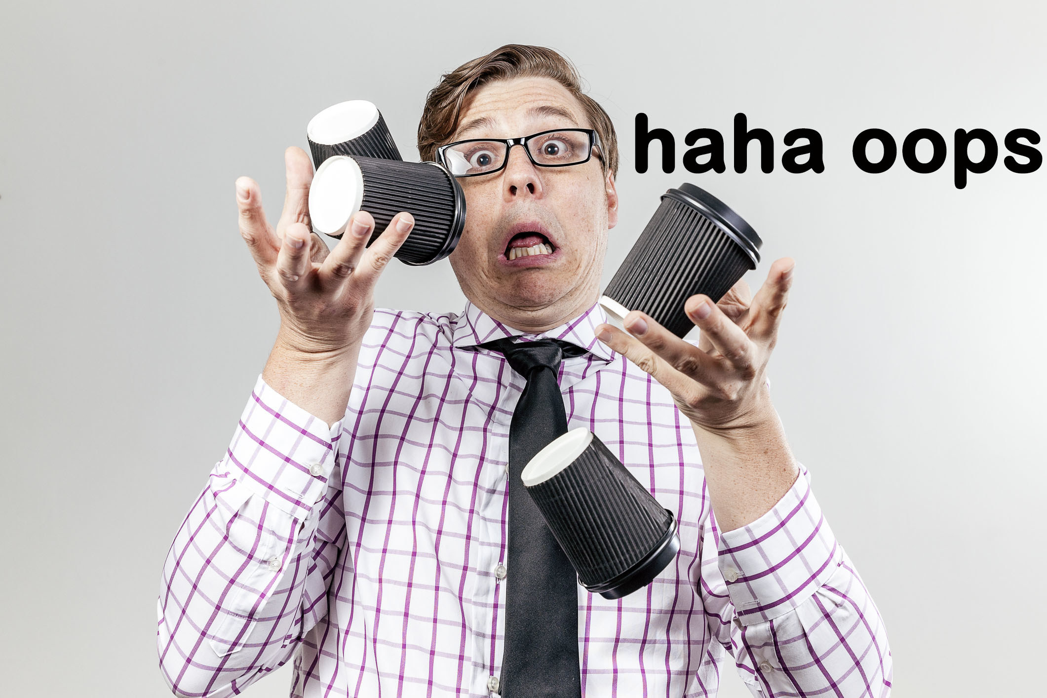 stock photo of a man dropping a bunch of cups of coffee and going, &quot;haha oops&quot;