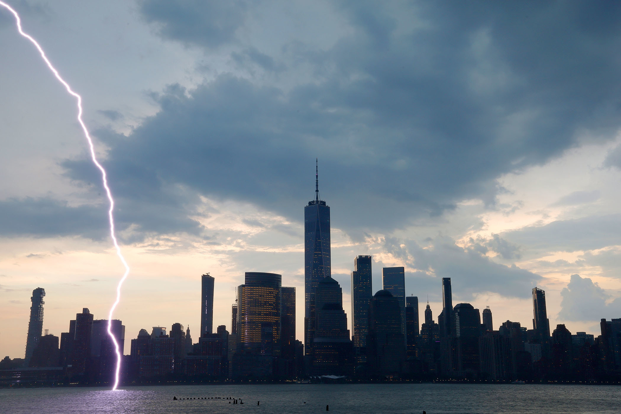 Lightning strikes the Hudson River; the skyline of buildings in New York&#x27;s Financial District stands in the background